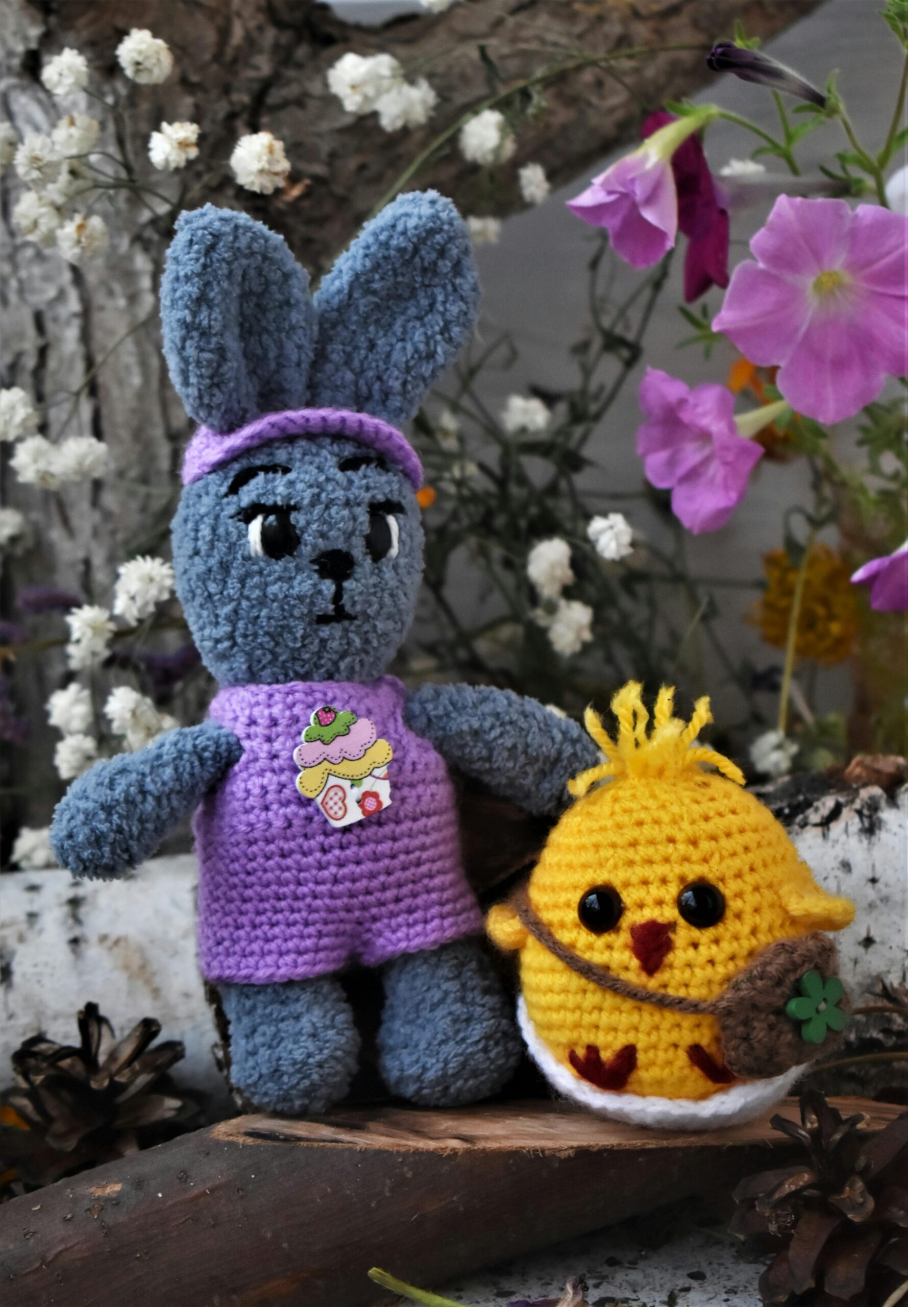 Colorful crochet toys in a natural setting surrounded by blooms.